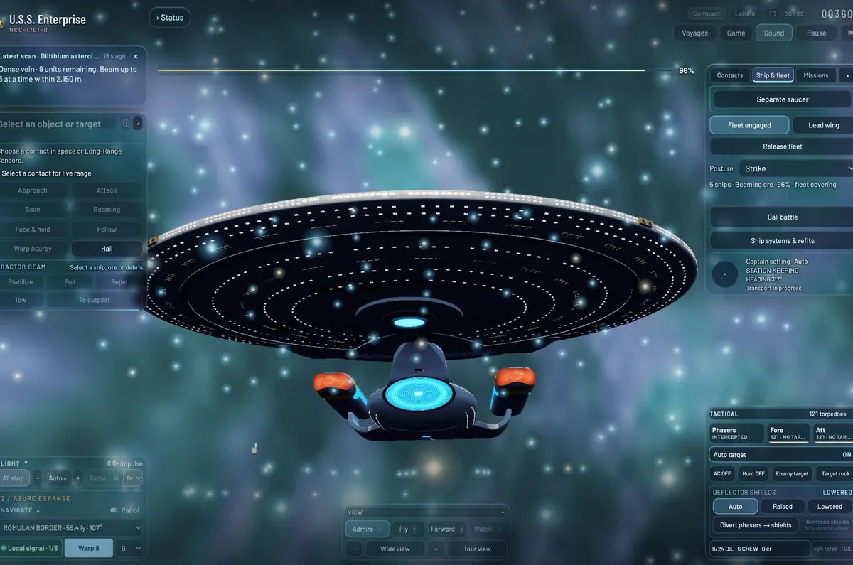 The Enterprise up close, head-on from just below, the deflector dish glowing blue, while ore is beamed aboard in a field of sparkling light.