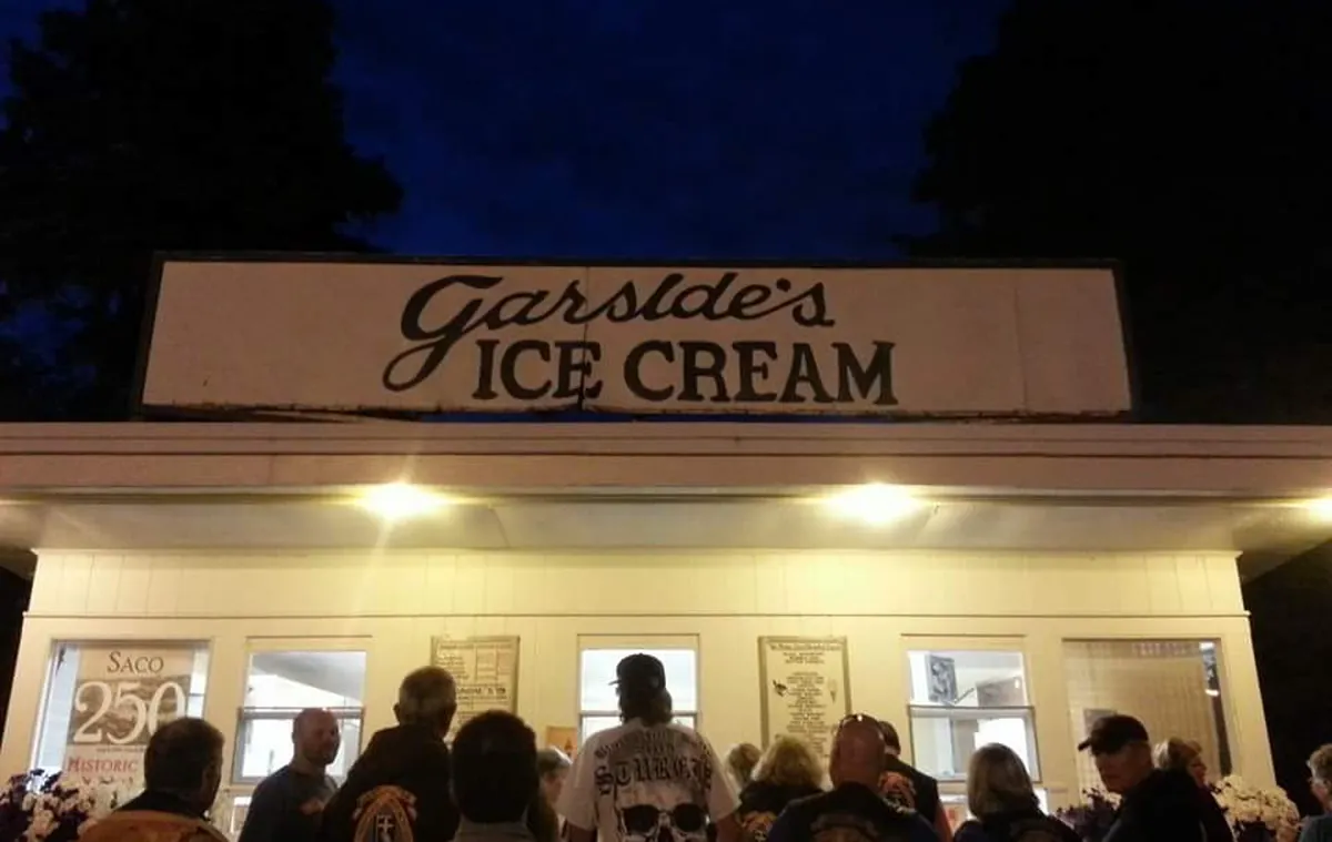 Garside's at night: the lit stand under its older sign, with a crowd of customers at the windows.