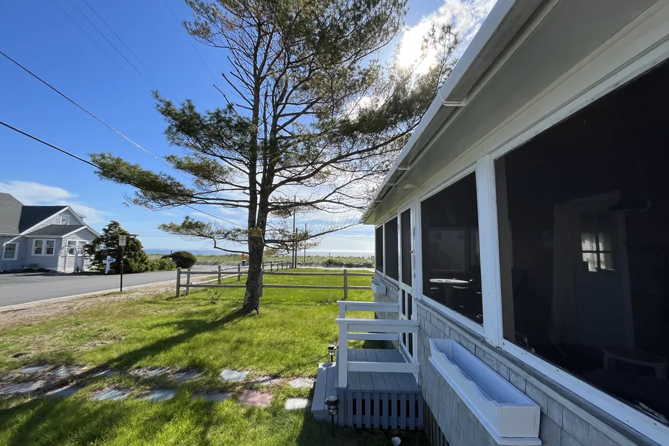 The cottage's yard in Saco with the beach in the background.