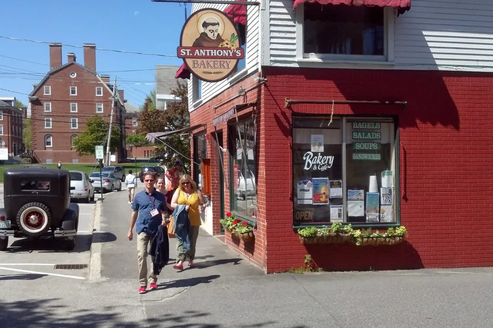 A bakery on a corner in the town of Exeter, friends walking past.