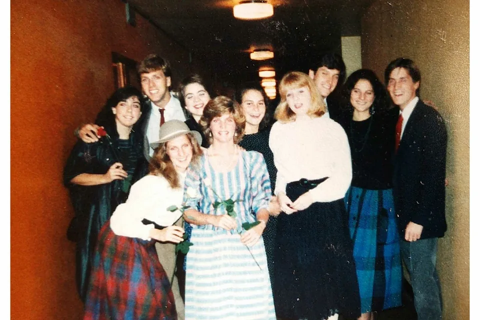 A group of junior-year-abroad students in 1980s dress posing in a hallway in Paris.